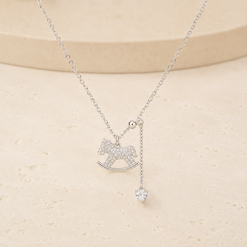 Lucky Rocking Horse Necklace on a warm ivory studio background